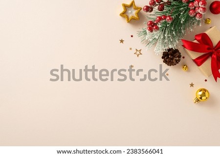 Share your warm wishes with this image idea. Top view of magnificent giftbox with red ribbon, sparkling ornaments, frosty fir, cone, holly berries, candle on light backdrop, ready for personalized ad