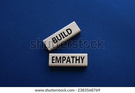 Build empathy symbol. Wooden blocks with words Build empathy. Beautiful deep blue background. Psychology and Build empathy concept. Copy space.