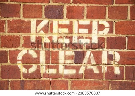 Photograph of Stenciled Keep Clear sign on Red Brick Wall Royalty-Free Stock Photo #2383570807