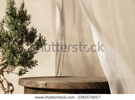 Natural wooden table and organic cloth with olive tree plant. Product placement mockup design background. Outdoor tropical summer scene with rustic vintage countertop display Royalty-Free Stock Photo #2383576017