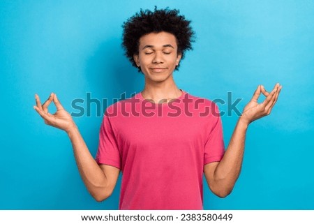 Photo of calm peaceful guy wear pink stylish clothes hands showing om symbol isolated on blue color background
