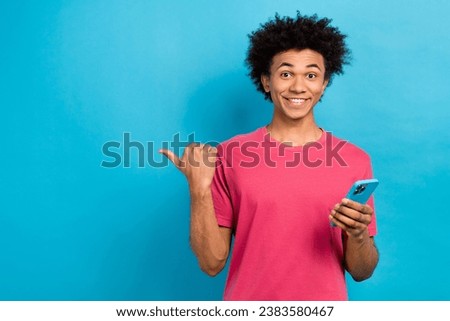 Photo of cheerful cool guy popular blogger wear stylish pink clothes promote novelty empty space isolated on blue color background