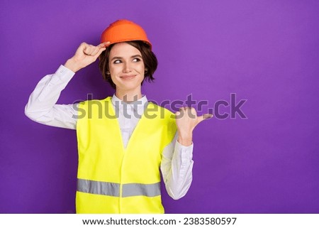 Photo of optimistic nice brunette hair lady point look empty space wear builder uniform isolated on purple color background