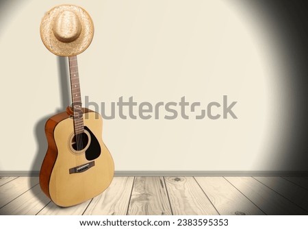 Acoustic guitar, against a wooden plank background