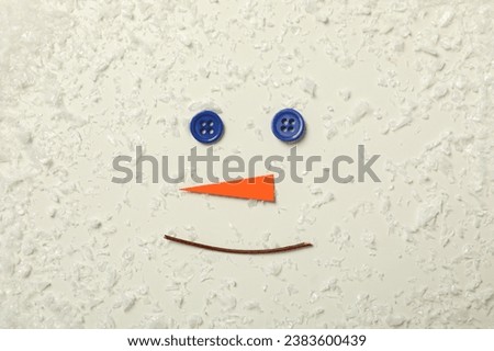 Snowman face with paper carrot and buttons