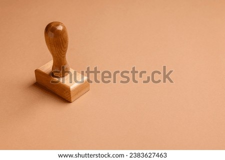 One wooden stamp tool on light brown background, space for text