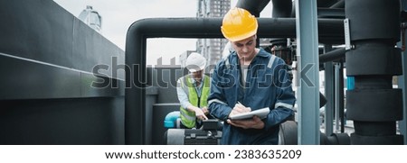 Engineer and team examining the air conditioning cooling system of a huge building or industrial site. Royalty-Free Stock Photo #2383635209