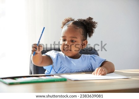 African child girl pick up color pencil and drawing on paper