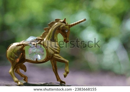Unicorn figurine on a green background. Royalty-Free Stock Photo #2383668155