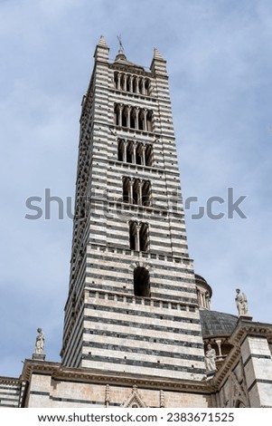 Duomo di Siena, church with a brown and white stone steeple, Italy