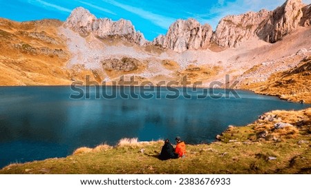 A Love At Its Peak: Enthralled Couple Gazing at the Beauty of Ibón de Acherito in Selva de Oza, Huesca, at the Heart of the Pyrenees




