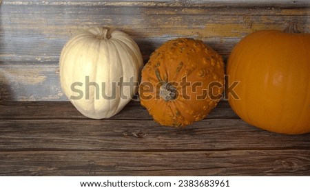 Three  pumpkins  on a wooden table  