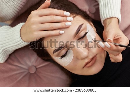 cosmetologist removes glue cotton strip under eye. Eyelash extension procedure Royalty-Free Stock Photo #2383689805