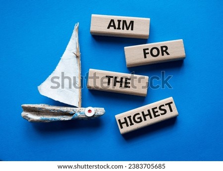 Aim for the Highest symbol. Concept words Aim for the Highest on wooden blocks. Beautiful blue background with boat. Business and Aim for the Highest concept. Copy space.