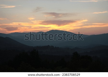 Sunset sunrise mountains mist in the forest silhouette trees frame the view America USA North Carolina Blue Ridge Mountains 