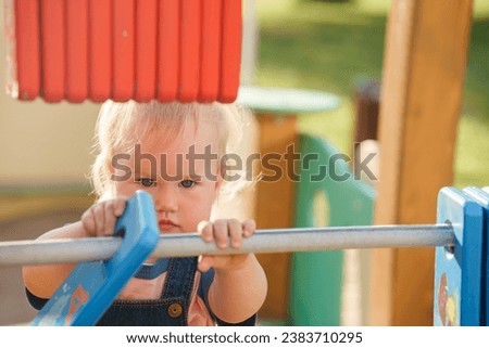 Baby kid plays with bills on the playground
