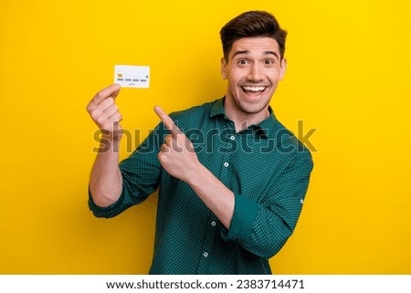 Photo of excited cheerful man banker wear stylish clothes hold plastic debit card hand advice offer isolated on yellow color background