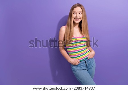 Photo of cute schoolgirl with straight hairdo dressed striped top look at sale empty space arms in pockets isolated on violet background