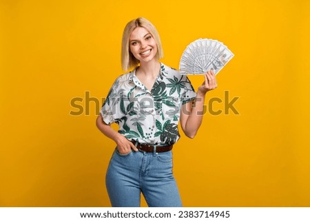 Photo portrait of pretty young girl hold banknotes fan money dressed stylish leaves print outfit isolated on yellow color background