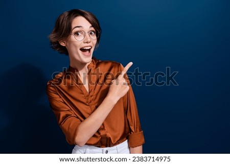 Photo portrait of lovely young lady point excited shocked empty space wear trendy brown blouse isolated on dark blue color background