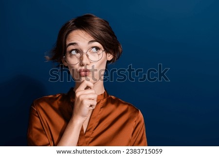 Photo of lovely minded girl dressed stylish clothes looking up empty space hmm question isolated on dark blue color background