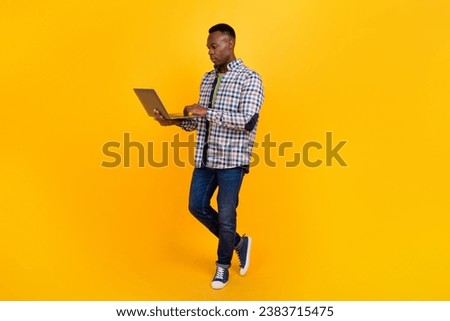 Full length body photo of young serious businessman concentrated doing his job online on freelance isolated over yellow color background