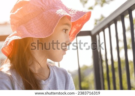 girl in a panama hat looks to the left Royalty-Free Stock Photo #2383716319