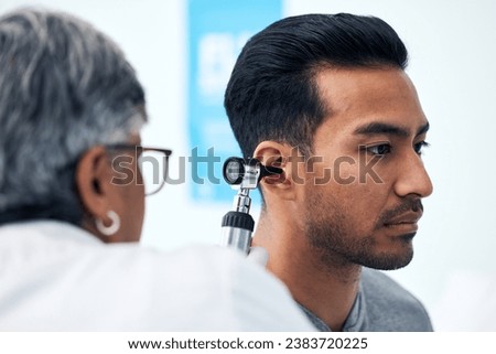 Ear check, man and ENT doctor with patient consultation for hearing and wellness at hospital. Senior, employee and otoscope test of physician with healthcare work and consulting exam with expert Royalty-Free Stock Photo #2383720225