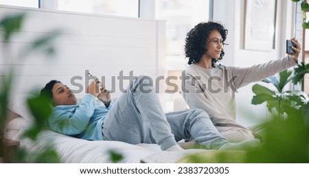 Smile, phone and lesbian couple on bed in selfie, love and relax together in eco friendly apartment. Cellphone, social media and digital photography, happy lgbt women in bedroom in home with plants.