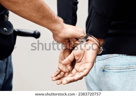 Man, police and handcuffs on criminal for arrest, crime or justice in theft, robbery or violence in city. Closeup of male person, officer or security guard cuffing hands of suspect, thief or gangster Royalty-Free Stock Photo #2383720757