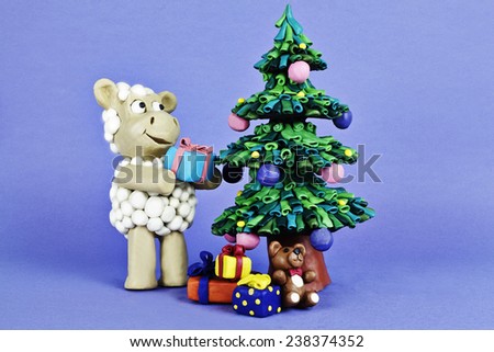 Clay sheep with gifts near Chrismas tree