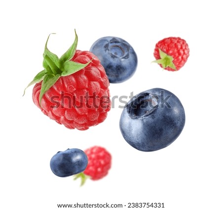 Fresh ripe blueberries and raspberries falling on white background Royalty-Free Stock Photo #2383754331