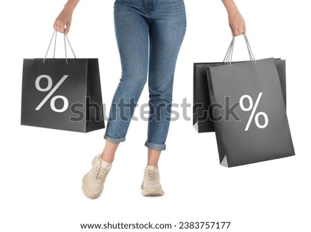 Discount, sale, offer. Woman holding paper bags with percent signs against white background, closeup