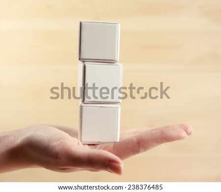 Educational cubes in hand, on wooden background