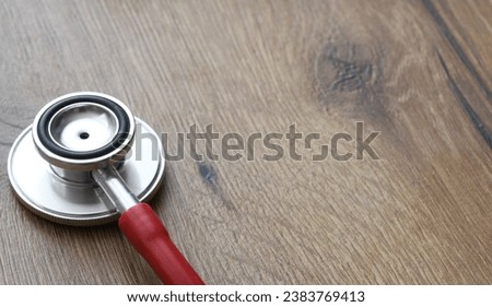 Red stethoscope on a wooden desk. healthcare.