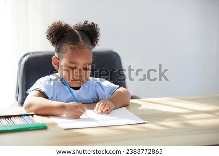 African child girl drawing with color pencil on paper