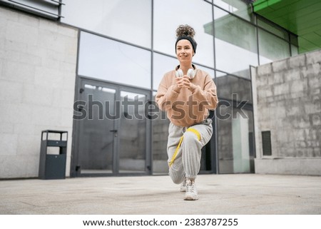 One woman adult caucasian female athlete training with elastic rubber resistance bands in outdoor in the city on concrete background stretching in happy brunette health and fitness concept copy space