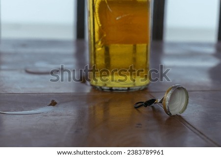 Picture of cap of a beer bottle and beer bottle in the background. Chilled alcohol, cold, soda, beach, bar, enjoy, waiter, hotel, pint, pitcher, mcdowell, ice, old monk, kingfisher, liquor, brand.