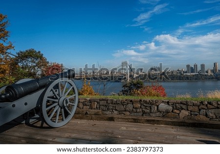 A cannon in the Fort Lee Historic Park, with New York city in the background in Autumn Royalty-Free Stock Photo #2383797373