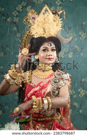Portrait of beautiful Indian girl of Durga Idol Agomoni Concept Indoor Photo wearing traditional Indian saree, gold jewellery, and bangles. Maa Durga agomoni shoot concept.Indian culture durga puja