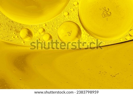 Gold drops of oil or serum texture background. Abstract yellow fluid with bubbles Royalty-Free Stock Photo #2383798959