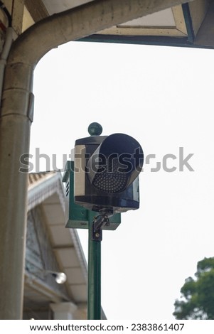 Red traffic light with a white sky background