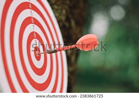 close up red dart arrow hitting on target center of dartboard, sport and recreation, planning and manage to success business concept