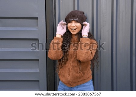 Cheerful Young indian woman enjoying in winter warm clothes with cap
