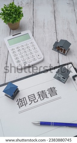 It is written in Japanese as "estimate".Wooden background, calculator and miniature house.