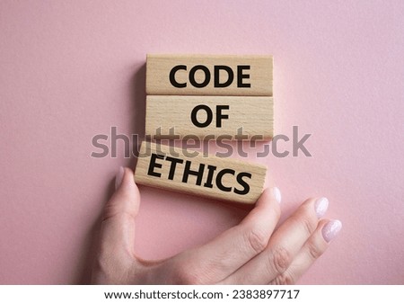 Code of ethics symbol. Concept words Code of ethics on wooden blocks. Businessman hand. Beautiful pink background. Business and Code of ethics concept. Copy space.