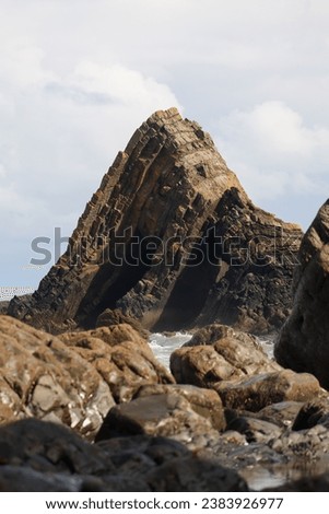 Coastal pictures of cornwall with rock formation and crushing waves.
