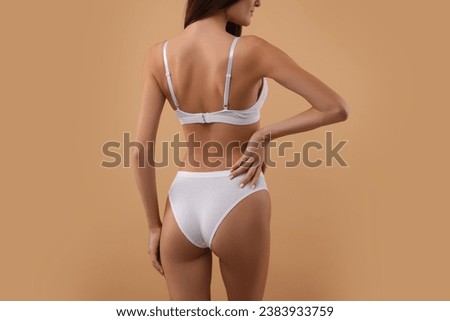 Young woman in stylish white bikini on beige background, closeup