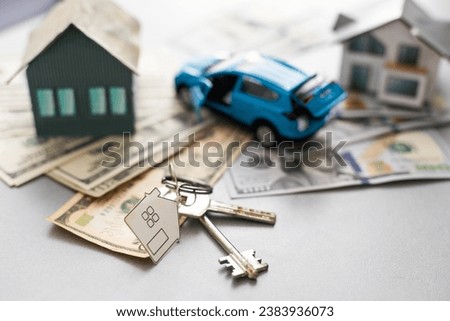 Close up of model house and car, money on white table. Real estate, home loan and investments concept