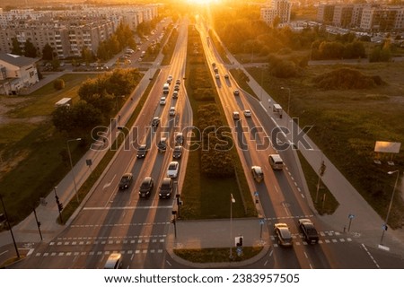 Drone photography of high traffic road surrounded by buildings during autumn sunset